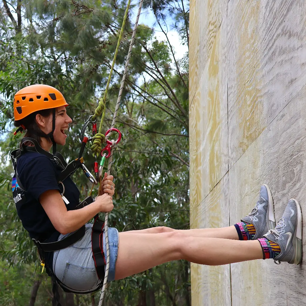 A mum wearing a helmet and climbing rope at a mum and daughter camp