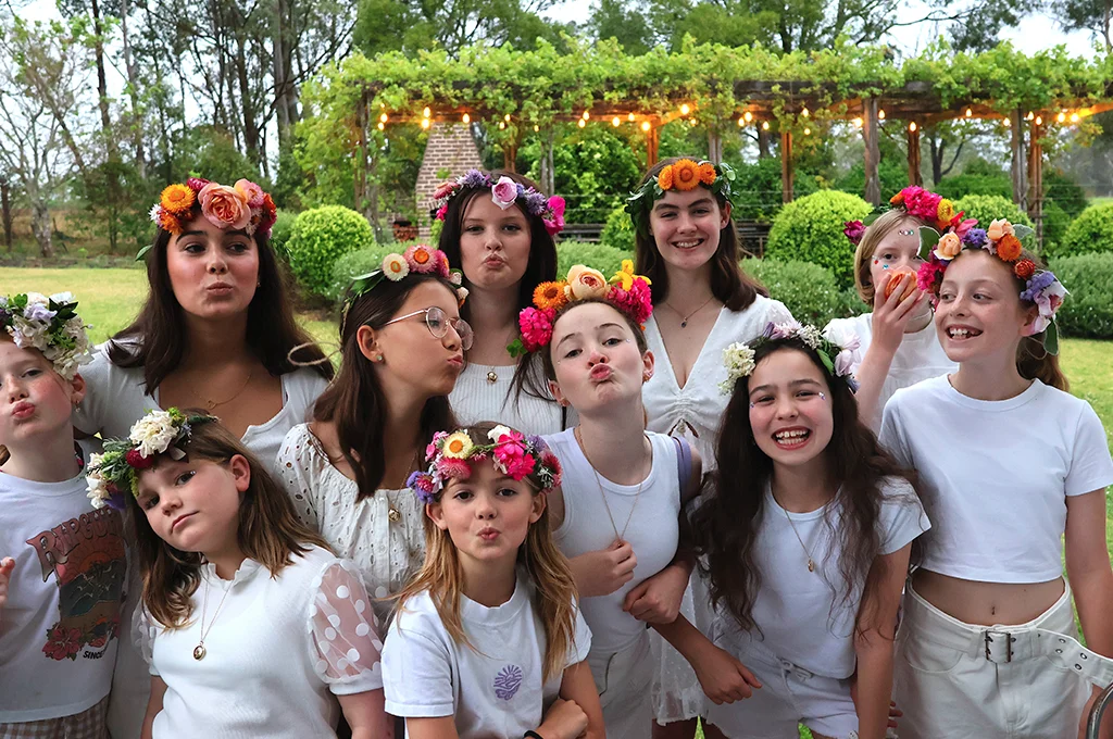 A group of girls wearing white and flowers on their head