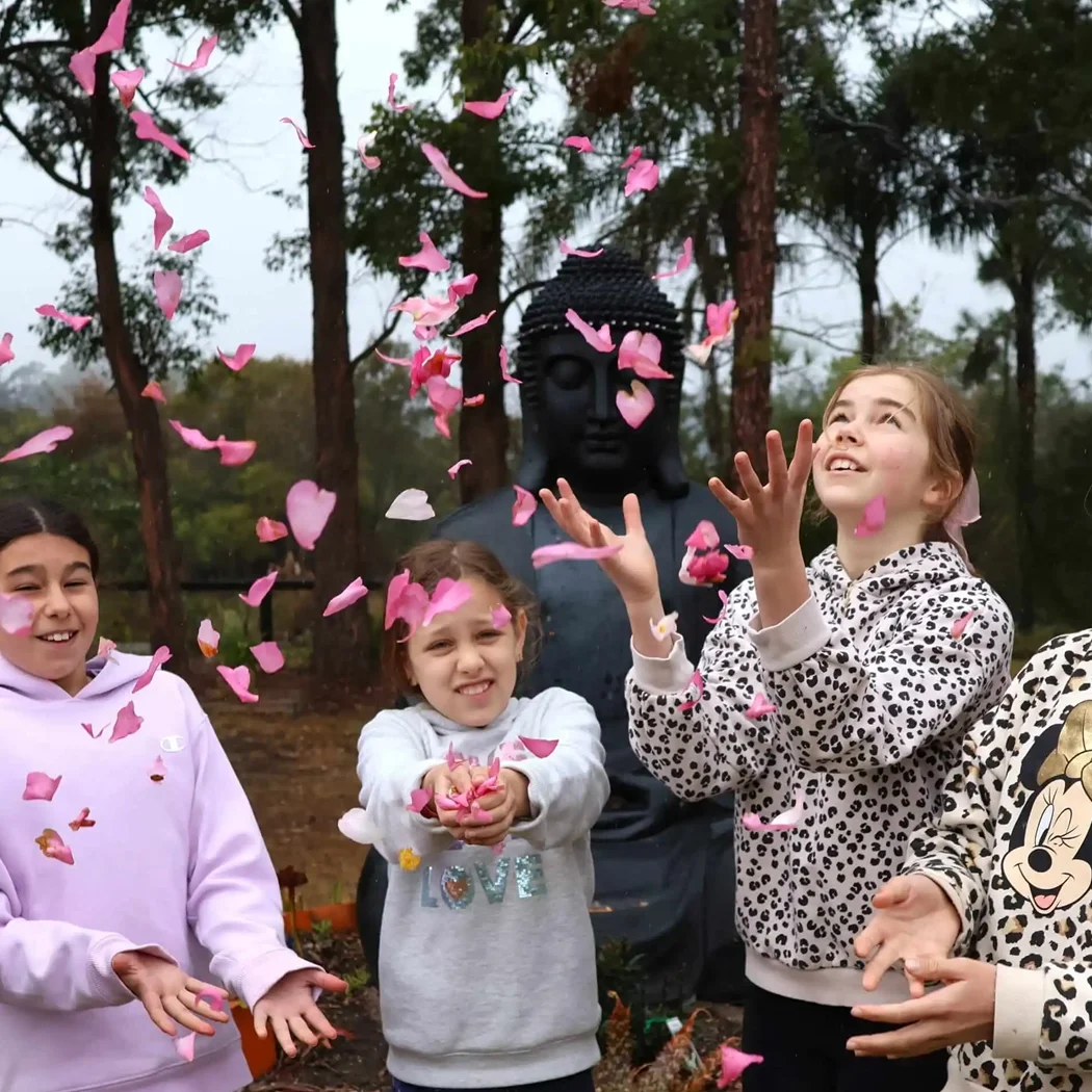 A group of children throwing petals in the air at a beautiful minds workshop