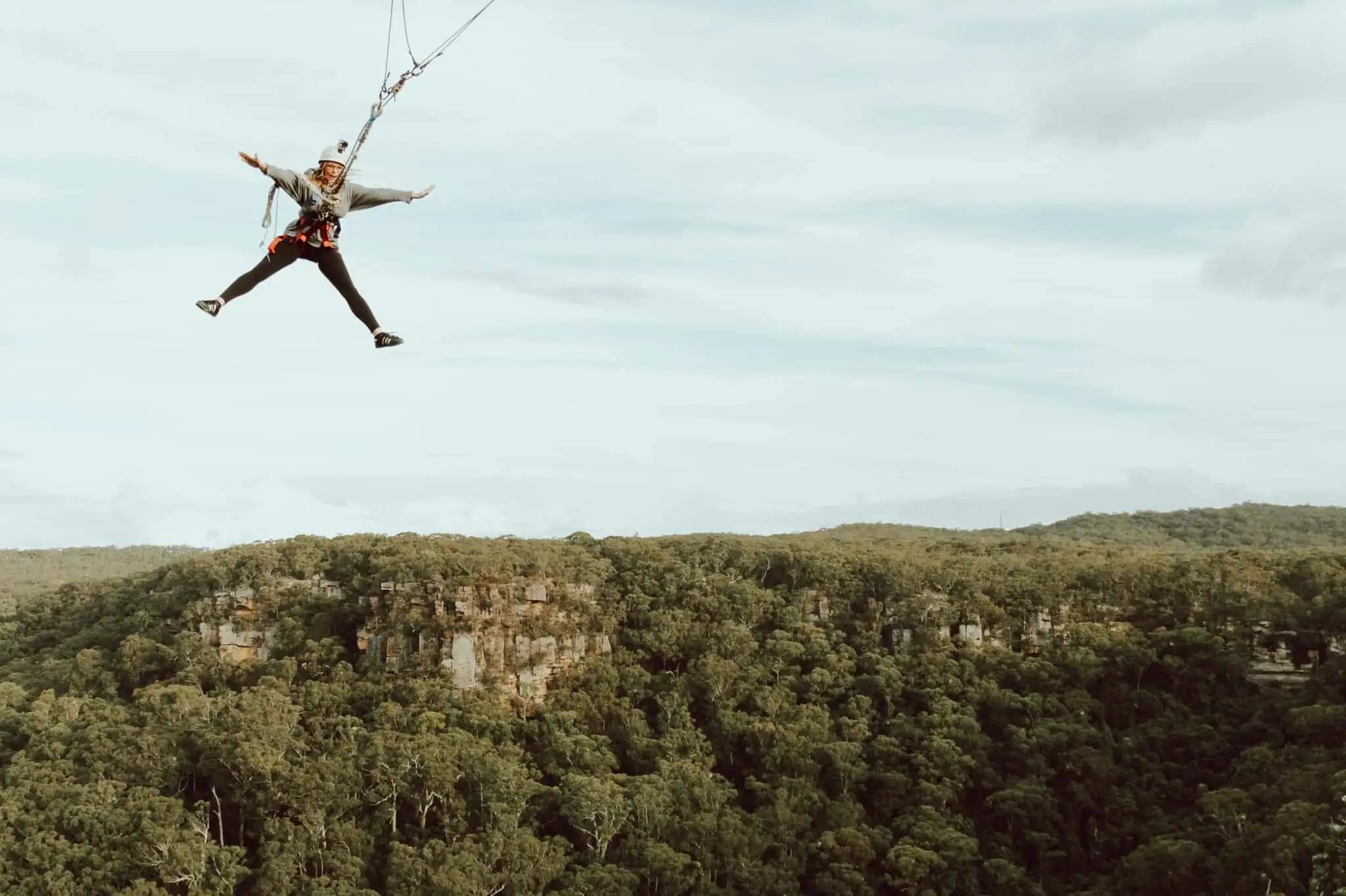 Woman on a swing over a forest